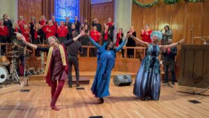 Dancers with the Shades of Praise gospel choir in the background.